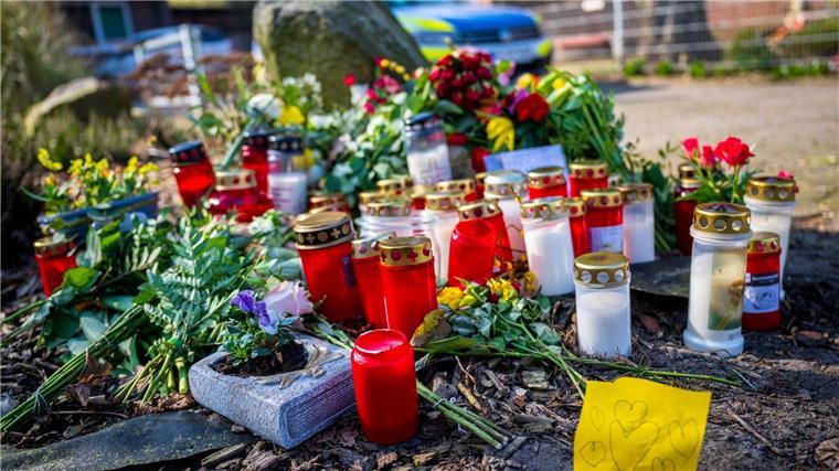 Gedenken an die vier Opfer tödlicher Schüsse Blumen und Kerzen liegen vor einem Einfamilienhaus.