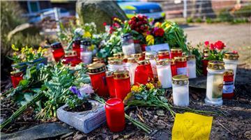 Blumen und Kerzen liegen vor einem Einfamilienhaus.