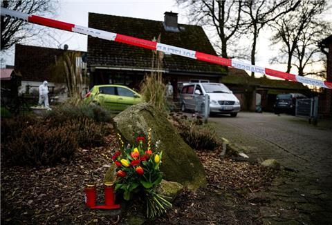 Blumen und Kerzen liegen vor einem Einfamilienhaus in der Gemeinde Scheeßel.
