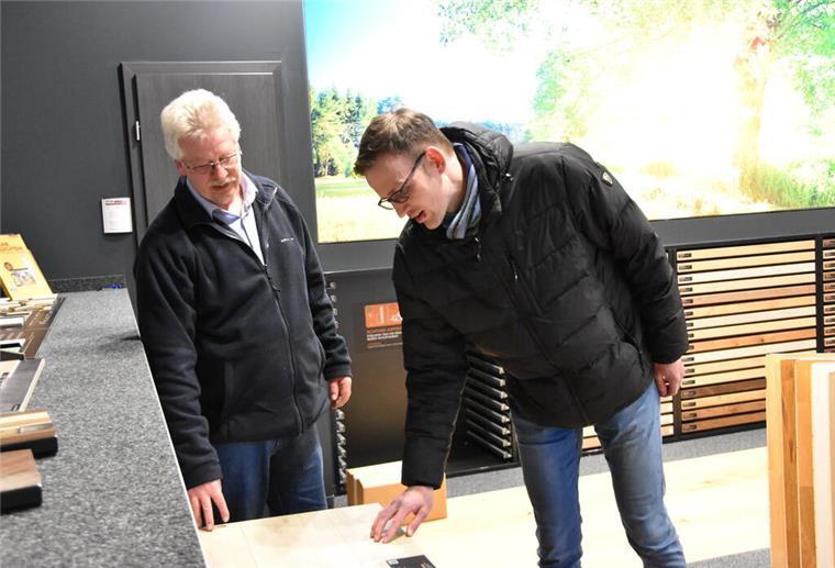 Das Hasselbring Baufachzentrum begeistert Besucher mit neuen Ausstellungen Zwei Männer schauen sich einen Bodenbelag an.
