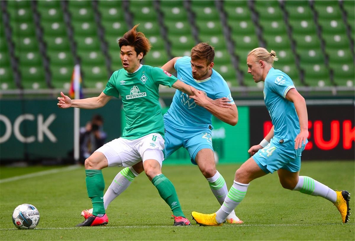 Bremens Yuya Osako (links) kämpft mit den Wolfsburger Marin Pongracic (Mitte) und Xaver Schlager um den Ball.