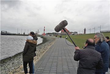 Bremerhaven ist unbedingt filmreif: Hier steht Regisseur Ulrich Scholz (vorne rechts) mit seinem Team bei Dreharbeiten am Deich.