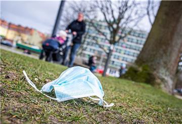 Eine getragene OP-Maske liegt auf dem Rasen.