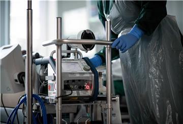 Eine Mitarbeiterin der Pflege steht in einem Zimmer der Corona-Intensivstation des Universitätsklinikums Essen und bedient ein ECMO-Gerät, eine Herz-Lungen-Maschine. 