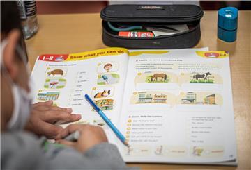 Schüler sitzt an einem Aufgabenheft.