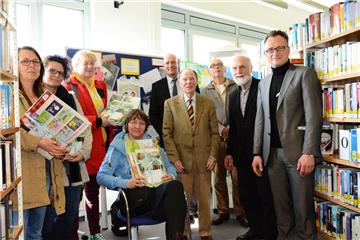 Bücherfreunde (fast) aller Altersklassen: Die Erzieherinnen der beschenkten Kindergärten gemeinsam mit den Vertretern der Sponsoren Michael Lichte (VGH, Mitte) und Wolfgang Weissenberg (Rotarier Cuxhaven, 4. von links) sowie Referent Dr. Jochen Hering (3. von links), Initiator Rolf Stindl (2. von links) und Schirmherr und Kreisrat Friedhelm Ottens (links) in der Stadtbibliothek Cuxhaven.