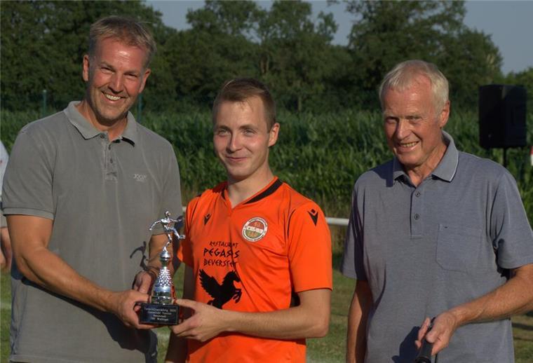 Der Wanderpokal ging an den MTV Bokel. Bürgermeister Guido Dieckmann (l.) und Vorsitzender Hans-Hermann Mehrtens (rechts) gratulieren Torschützenkönig Christian Hitzigrath.