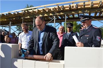 Bürgermeister Thorsten Krüger lässt die Röhre, in der unter anderem die NORDSEE-ZEITUNG steckt, ins Mauerwerk sinken.