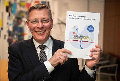 Bürgerschaftspräsident Frank Imhoff mit dem ersten Exemplar der Landesverfassung in Einfacher Sprache