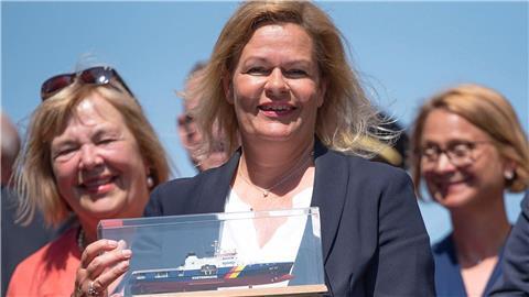 Bundesinnenministerin Nancy Faeser (SPD) hält nach der Taufe des Bundespolizeischiffs ein Modell davon in der Hand.