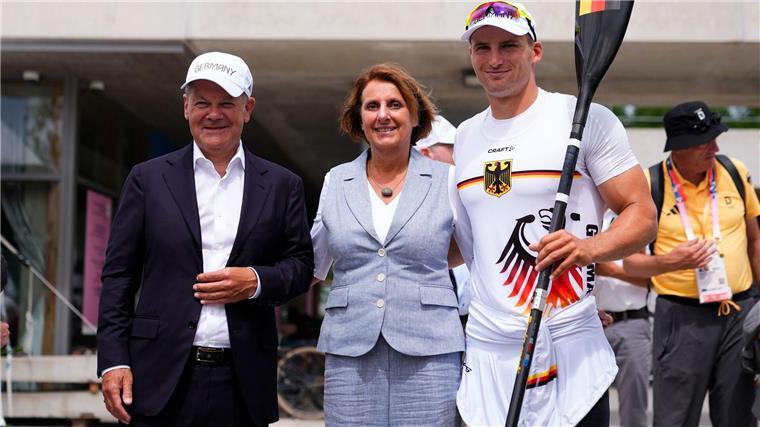 Bundeskanzler Olaf Scholz (l) und seine Frau Britta Ernst lassen sich mit Olympiasieger Tom Liebscher-Lucz fotografieren.
