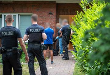 Bundespolizisten ermitteln vor einem Wohnhaus: Mit einer Razzia sind die Behörden gegen mutmaßliche Schleuser in Schleswig-Holstein, Hamburg und Niedersachsen vorgegangen.