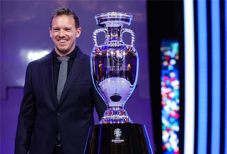 Bundestrainer Julian Nagelsmann steht neben der EM-Trophäe. Die Fußball-Europameisterschaft findet in Deutschland statt.