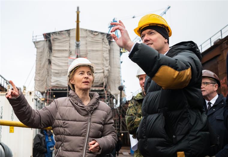 Bundesverteidigungsministerin Ursula von der Leyen (CDU) steht bei ihrem Besuch der "Gorch Fock"  in Bremerhaven mit weiteren Personen im Dock. 