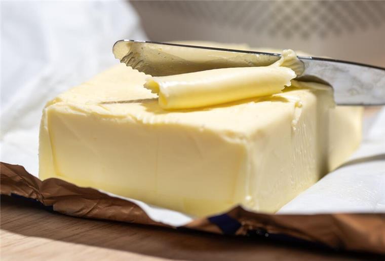 Butter oder Margarine: Was ist wirklich gesünder fürs Frühstück? Ein Stück Butter liegt auf einem Tisch.