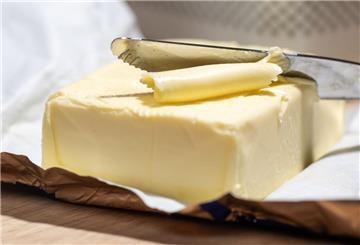 Ein Stück Butter liegt auf einem Tisch. (zu dpa: «Butterpreise könnten weiter steigen»)