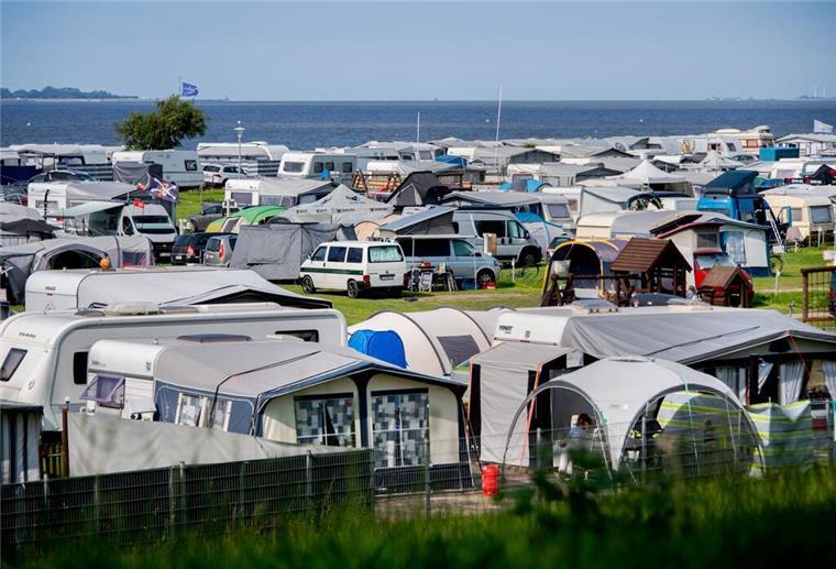 Wohnwagen und Wohnmobile stehen bei sonnigem Wetter auf einem Campingplatz