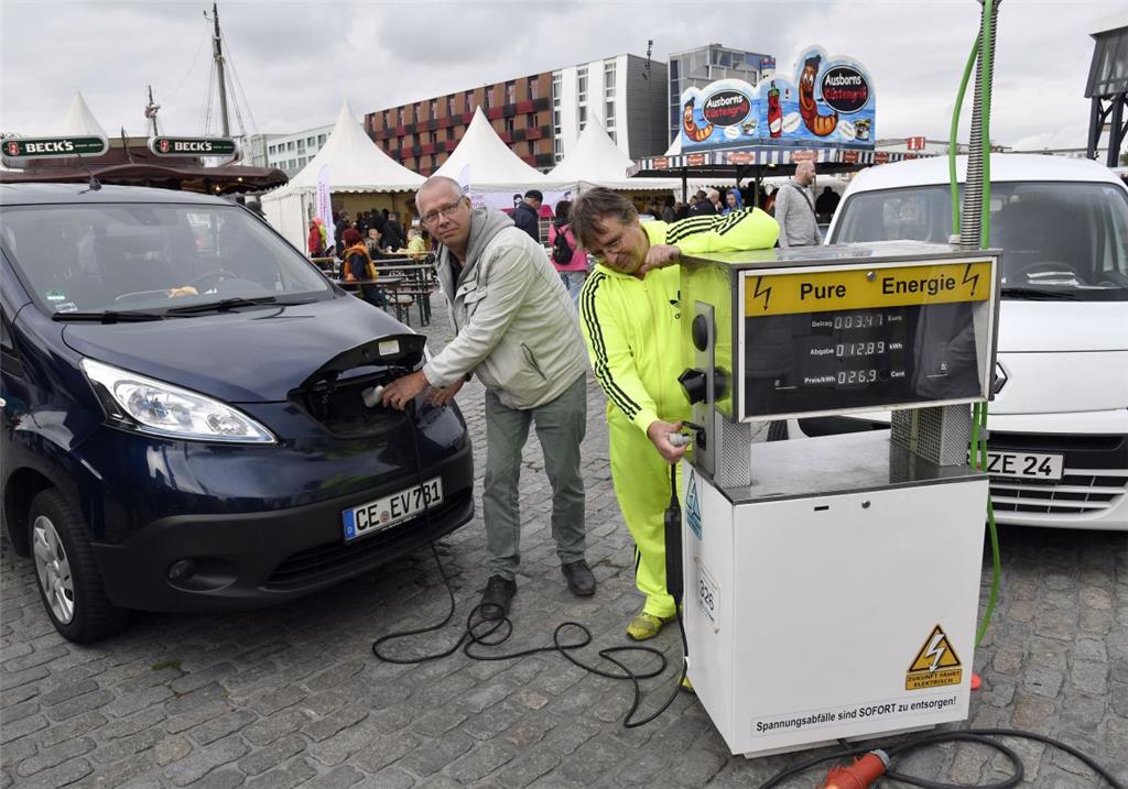 Carsten Hünecke (links) aus Bremen-Nord und Roland Klose setzen auf Elektromobilität und tanken bei den Energietagen im Fischereihafen auf.
