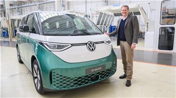 Carsten Intra, Vorstand Volkswagen Nutzfahrzeuge, steht neben einem Elektrobus Volkswagen ID.Buzz im Werk von Volkswagen Nutzfahrzeuge in Hannover.