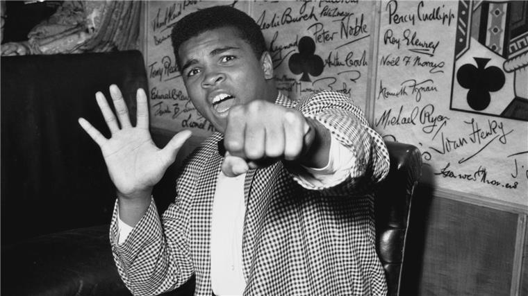Cassius Clay, besser bekannt als Muhammad Ali, hält fünf Finger hoch, um vorauszusagen, wie viele Runden er brauchen wird, um Henry Cooper auszuknocken.