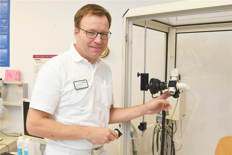Chefarzt Dr. Hans Jörg Baumann demonstriert im Ameos-Klinikum Am Bürgerpark ein medizinisches Gerät zur Messung der Lungenfunktion.