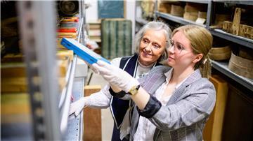 Christine Strüfing (l), ehemalige Lehrerin, und Lea Finzel, Kuratorin, schauen sich im Kiekeberg-Museum verschiedene Exponate an. Christine Strüfing trug tausende Objekte aus der Schule zusammen.