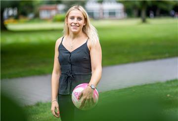 Fußballerin Cindy König steht mit Ball im grünen Park