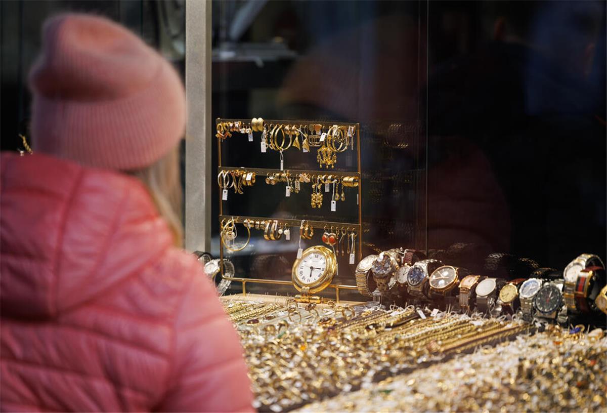 Eine Passantin steht vor der Auslage eines Geschäftes für Uhren und Schmuck
