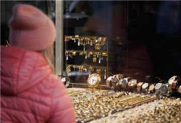 Eine Passantin steht vor der Auslage eines Geschäftes für Uhren und Schmuck