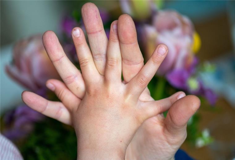 Eltern nennen Kinder als wichtigste Kraftquelle in Krisenzeiten Eine Mutter hält die Hand ihrer Tochter.