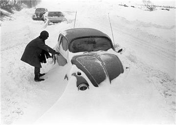 Cuxhaven: Ein Autofahrer steht neben seinem am Straßenrand im Schnee stecken gebliebenen VW-Käfer, aufgenommen bei Cuxhaven am 31.12.1978.
