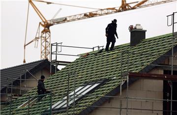 Dachdecker arbeiten auf dem Dach eines Neubaus: Niedrige Zinsen sorgen für eine gute Auftragslage im Bauhandwerk.