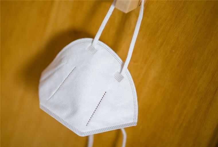 Eine FFP2-Maske hängt an einem Haken.