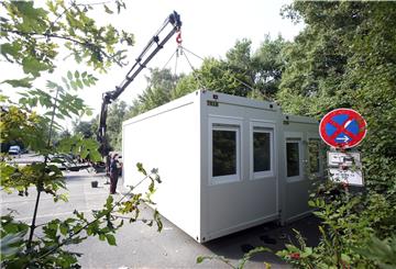 Arbeiter stellen Wohncontainer auf.
