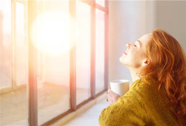 Frau hält ihr Gesicht in die Sonne