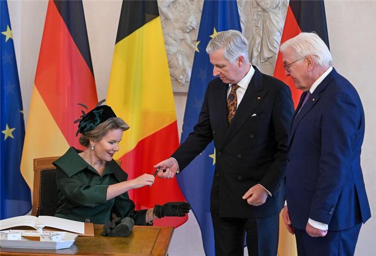 Das belgische Königspaar König Philippe (M) und Königin Mathilde tragen sich in das Gästebuch im Schloss Bellevue ein, rechts Bundespräsident Frank-Walter Steinmeier.