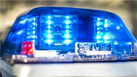 Das Blaulicht an einem Polizeiwagen ist eingeschaltet.