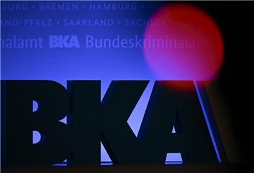 Das Rotlicht einer TV-Kamera leuchtet vor einem großen BKA-Logo.