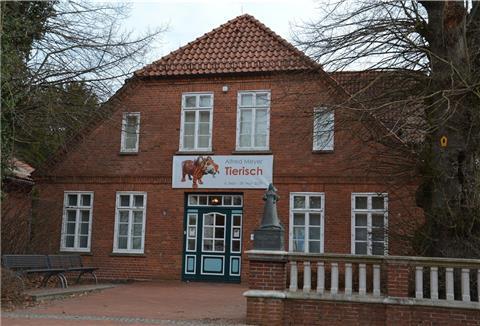 Das Christinenhaus in Zeven ist ein roter Backsteinbau mit einer Skulptur davor.