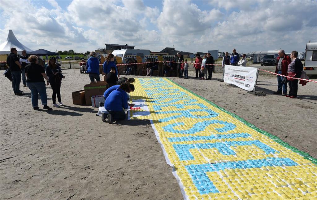 Das Cocktailschirmchen-Mosaik im Strand nimmt allmählich Gestalt an. 