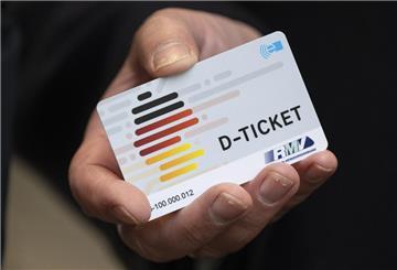  Eine Hand hält ein Deutschlandticket. 