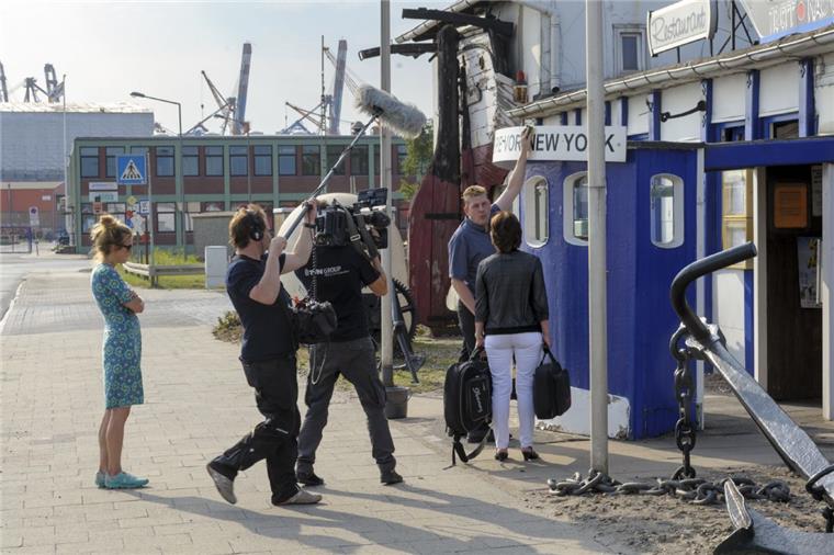 Das Drehteam des NDR filmt Kneipen-Wirt Martin Benecke beim Schrubben des Schildes mit dem Namen, der zum Markenzeichen geworden ist: Die letzte Kneipe vor New York.