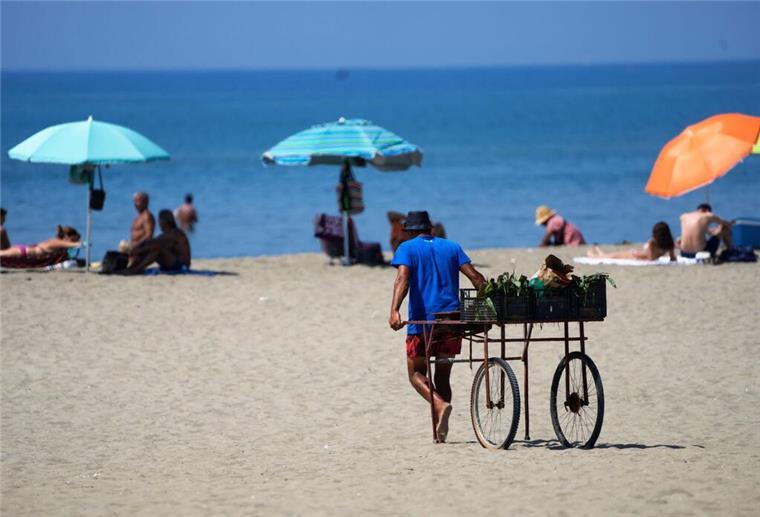 Urlaub an der Nordsee wird 2025 teurer - was Reisende erwartet Ein Strandverkäufer zieht seinen Wagen an einen Strand.