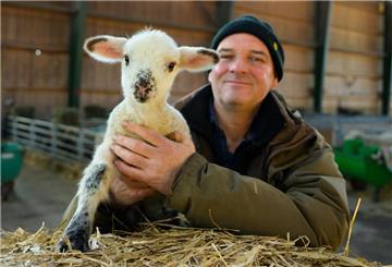 Stefan Erb, Schäfer, hält ein wenige Tage altes Lamm in den Händen. Die wochenlange Lammzeit Anfang des Jahres ist für Schäfer ein Dauerjob.