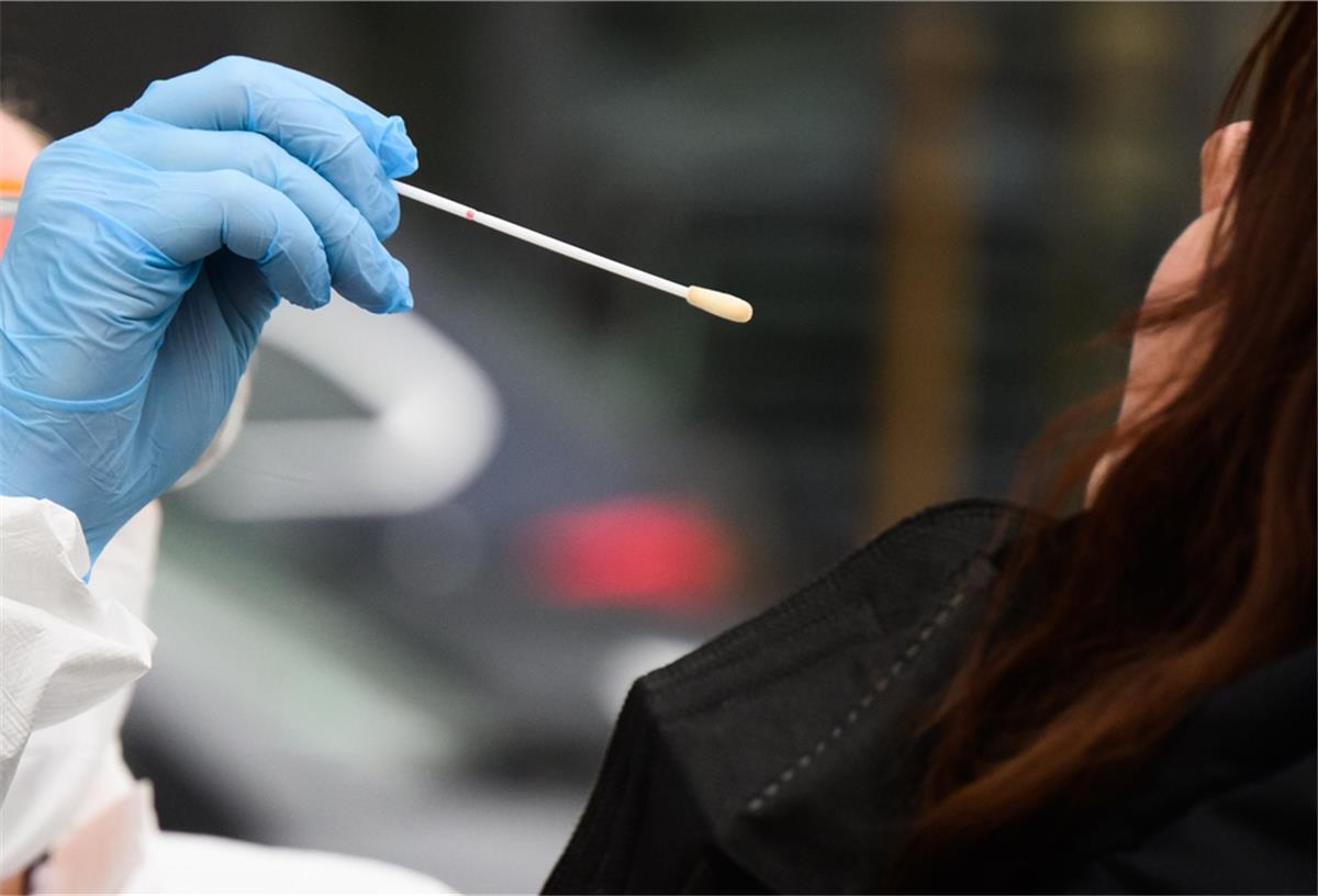 Eine Hausärztin nimmt einen Abstrich von einer Patientin für einen PCR-Test auf das Coronavirus