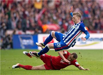 Das gibt eine Gelbe Karte: Bayerns Rafinha (unten) foult Herthas Mitchell Weiser bei einem Zweikampf.