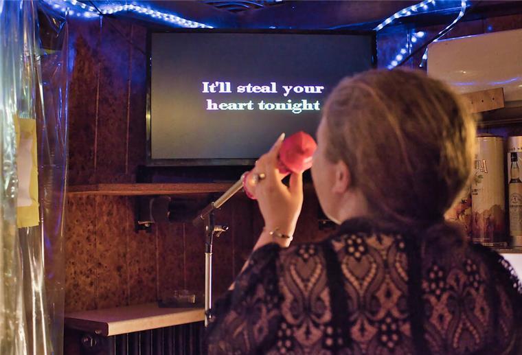Eine Frau singt Karaoke. 