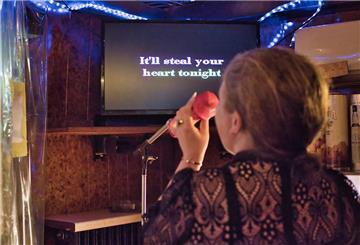 Eine Frau singt Karaoke. 
