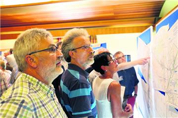 Das Interesse an der A20 ist groß: Werner Junge (vorne links) aus Osterndorf studiert zusammen mit anderen Besuchern der Info-Veranstaltung in Wollingst ganz genau den Trassen-Verlauf.