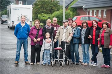 Das ist unsere Blaustraße: Die Anwohner (von links) Kim Gerriets, Anita Grasse, Nadine Brauckhof mit Sohn Philipp, Matthias Brauckhof, Walter Dieckelt, Inge Gerriets, Karin Schories,Petra Maas, Monika Hemme und Petra Janßen posieren auf der kleinen Wohnstraße am Südostrand von Surheide. Foto Ehrecke